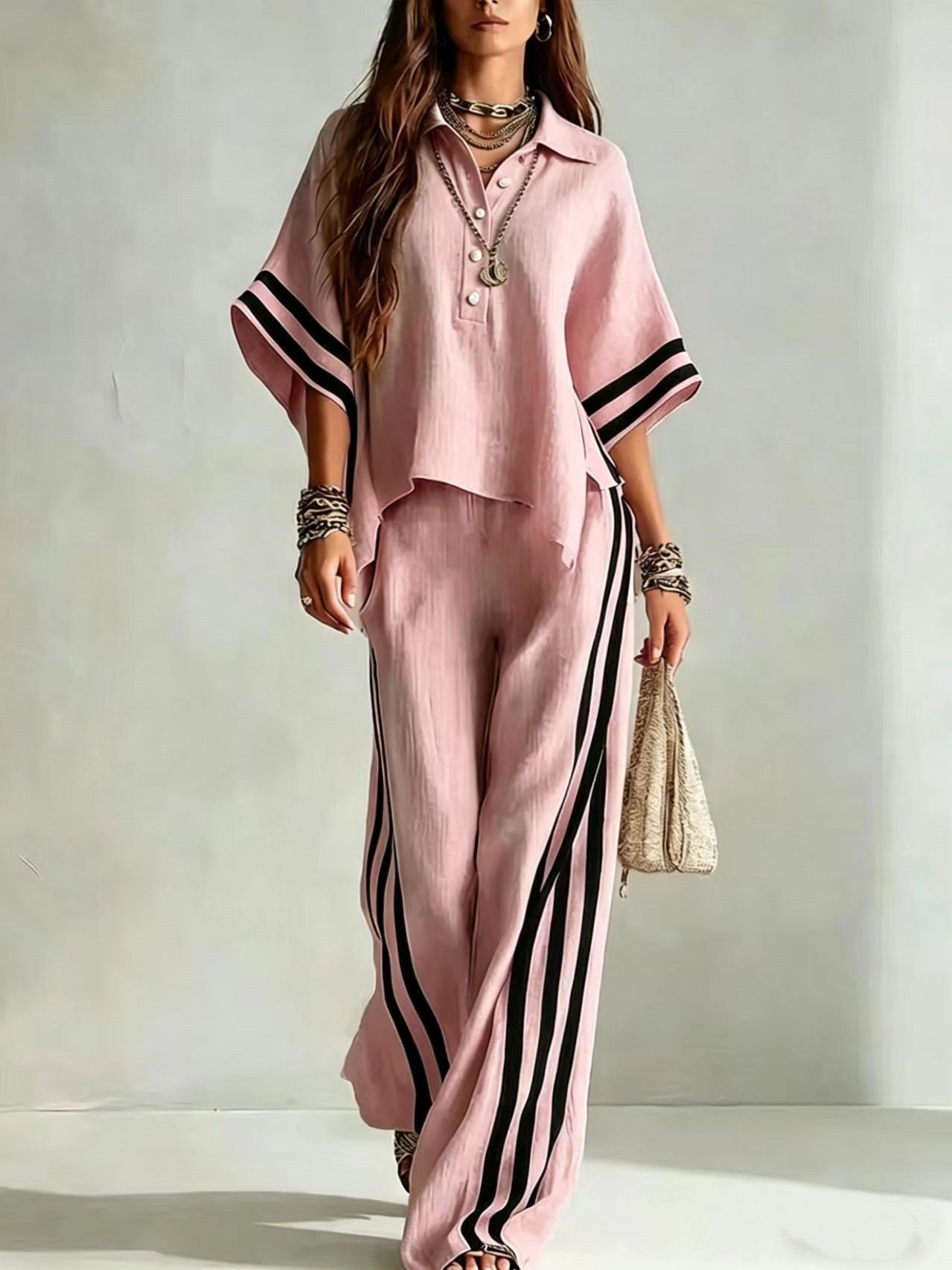 Woman wearing a pink outfit with black stripes on a plain background