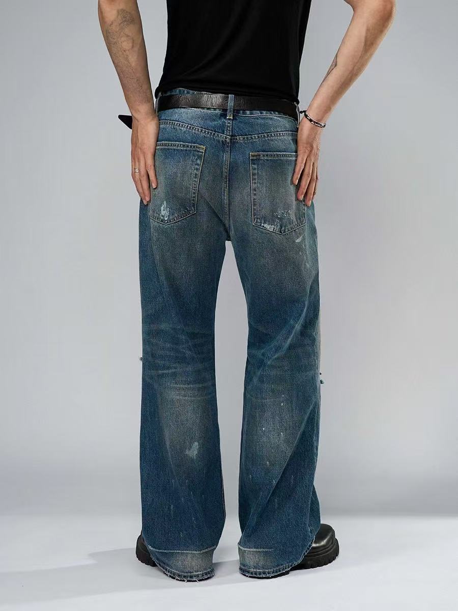 Person wearing blue jeans and a black shirt on a gray background