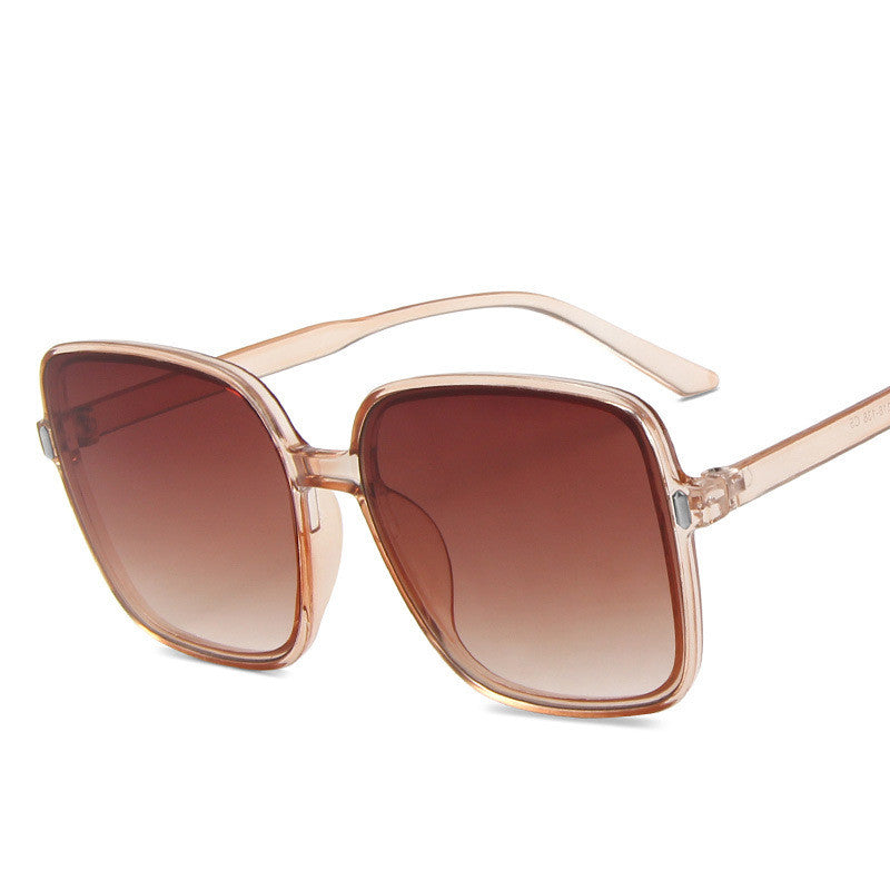 Sunglasses with rose gold frame and brown gradient lenses on a white background