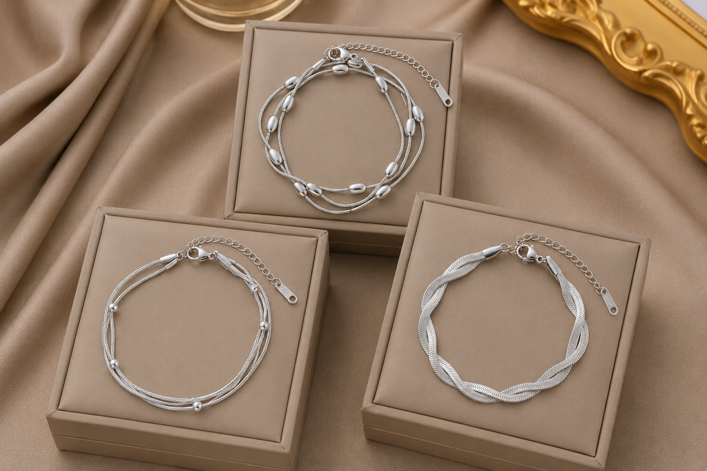 Silver bracelets on brown boxes with a gold frame in the background