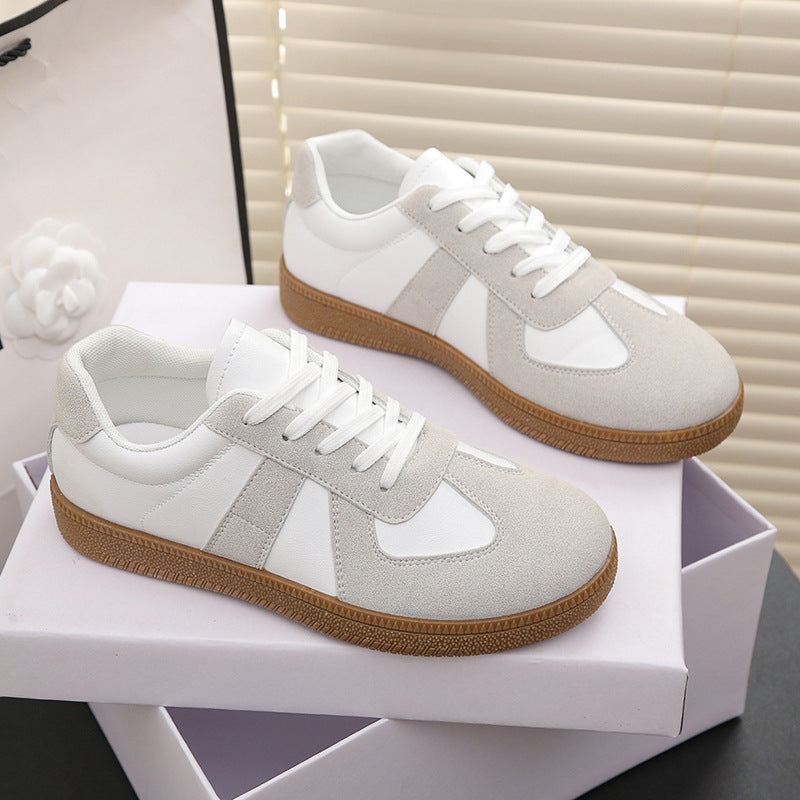 Pair of white and gray sneakers with brown soles on a white box.