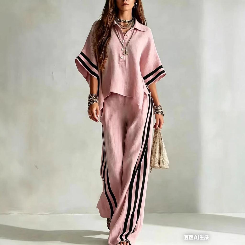 Woman wearing a pink outfit with black stripes on a plain background