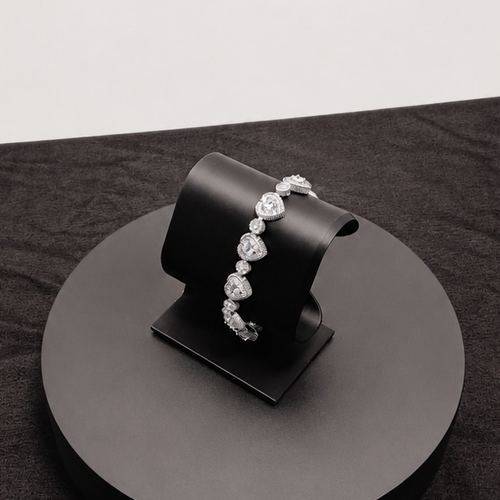 Black jewelry display stand with a bracelet on a dark surface