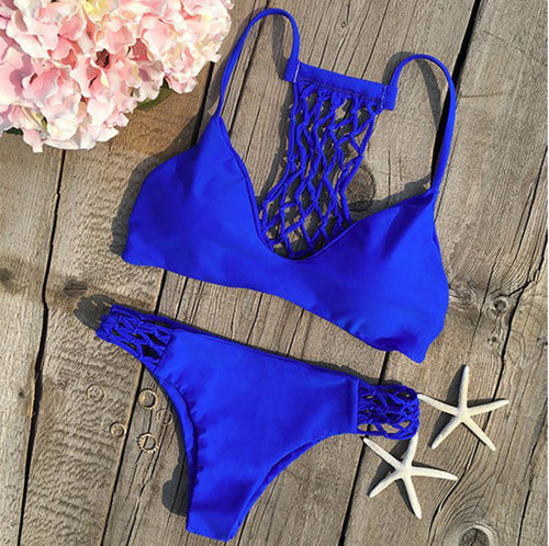 Blue bikini set on a wooden surface with flowers and starfish