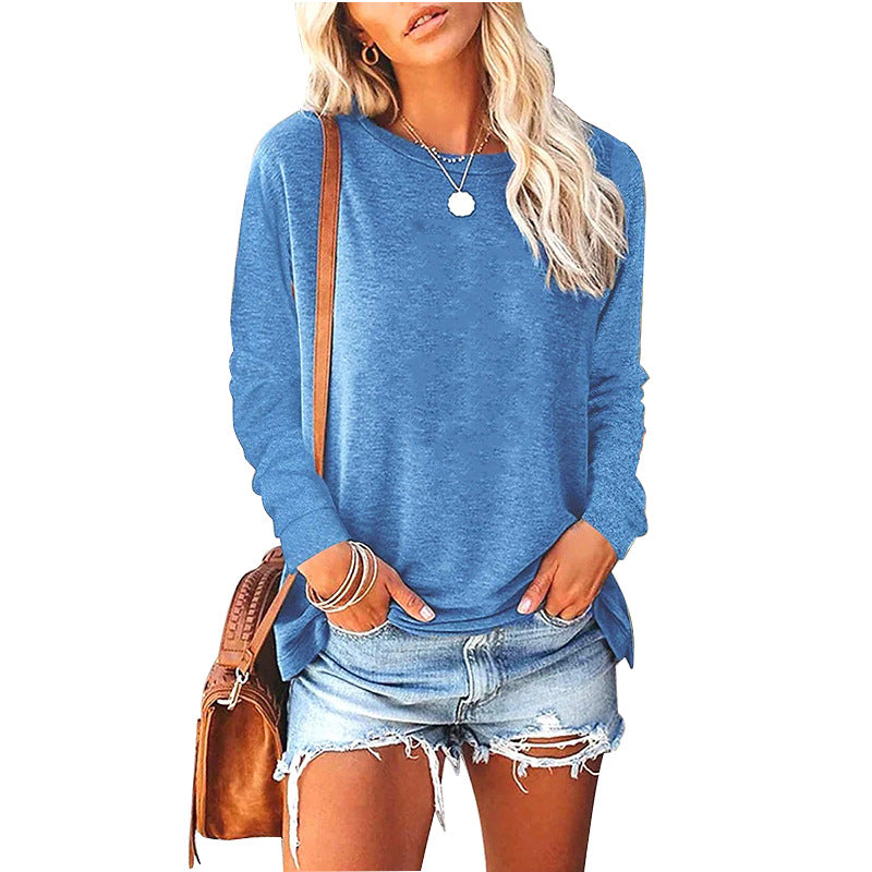 Woman wearing a blue sweater and denim shorts with a brown bag on a white background