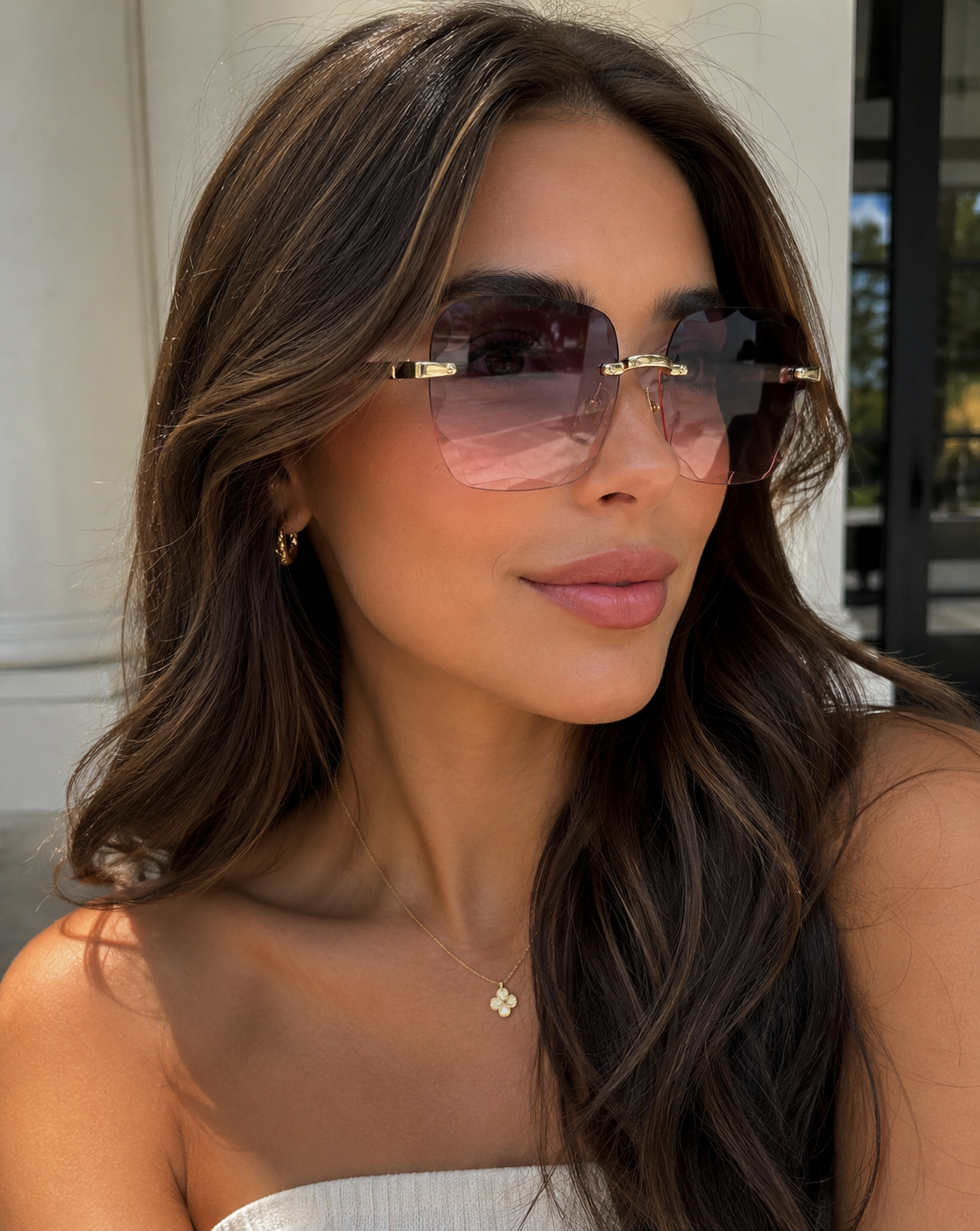 Woman wearing pink sunglasses with a blurred background