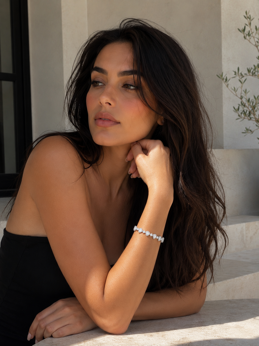 Woman with long dark hair wearing diamond bracelet 