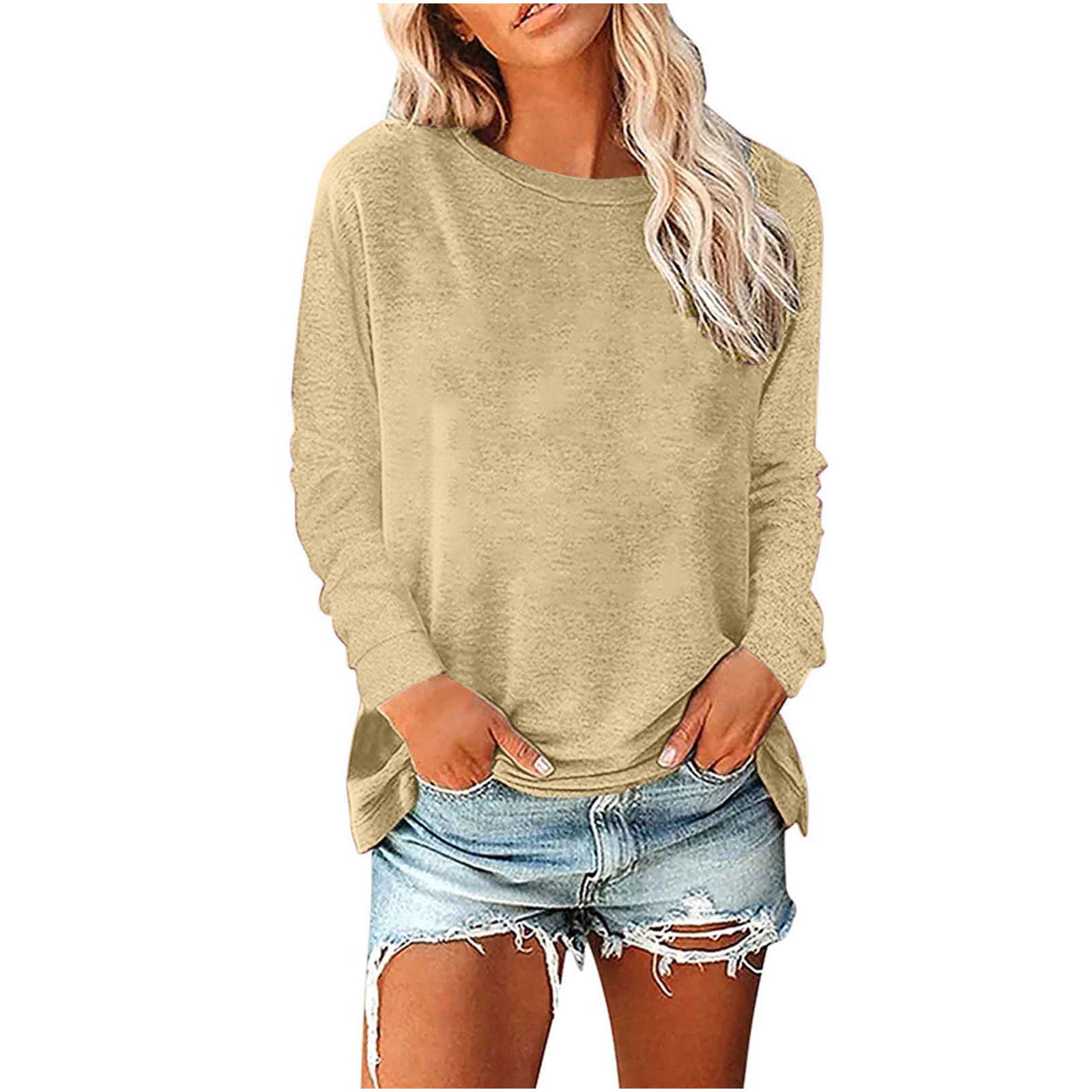 Woman wearing a beige long-sleeve top and denim shorts on a white background
