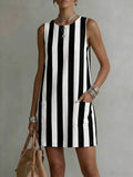 Woman wearing a black and white striped dress against a neutral background