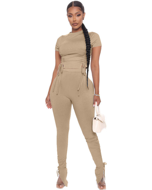 Woman wearing a beige jumpsuit on a white background