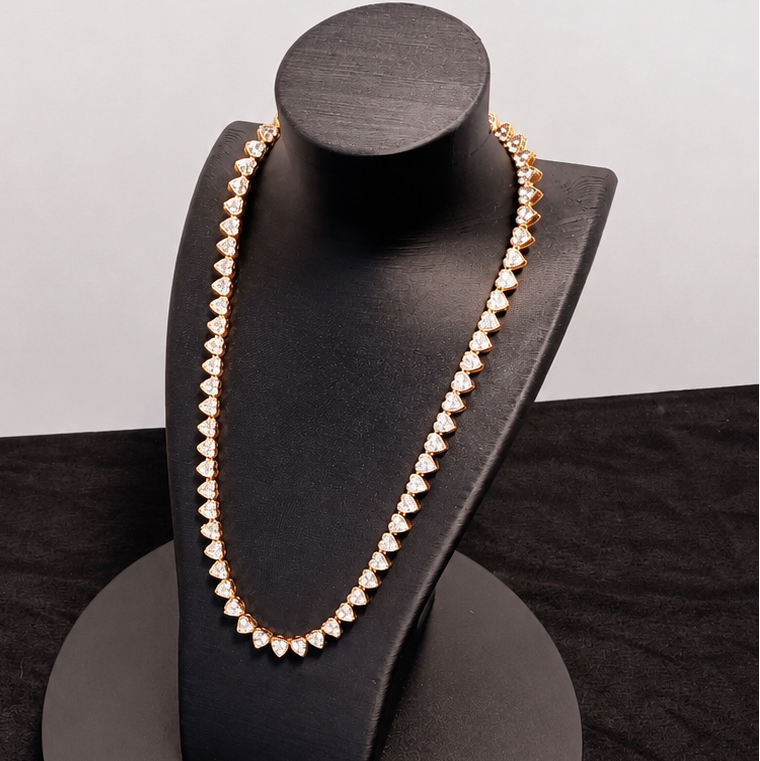 Gold necklace on a black jewelry stand against a white background