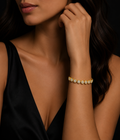 Woman wearing a gold bracelet with cz on a dark background