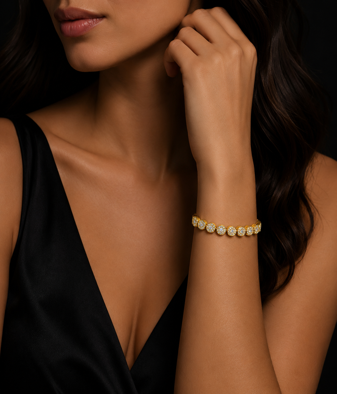 Woman wearing a gold bracelet with cz on a dark background