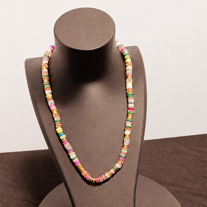 Colorful beaded necklace on a brown mannequin bust against a plain background