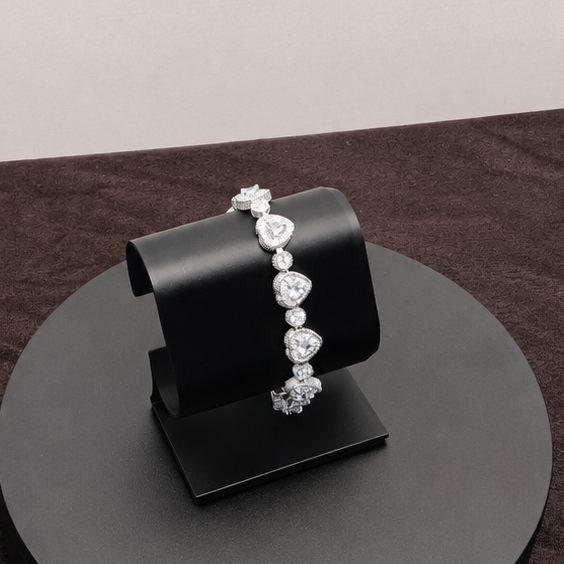 Black jewelry stand with a bracelet on a dark surface