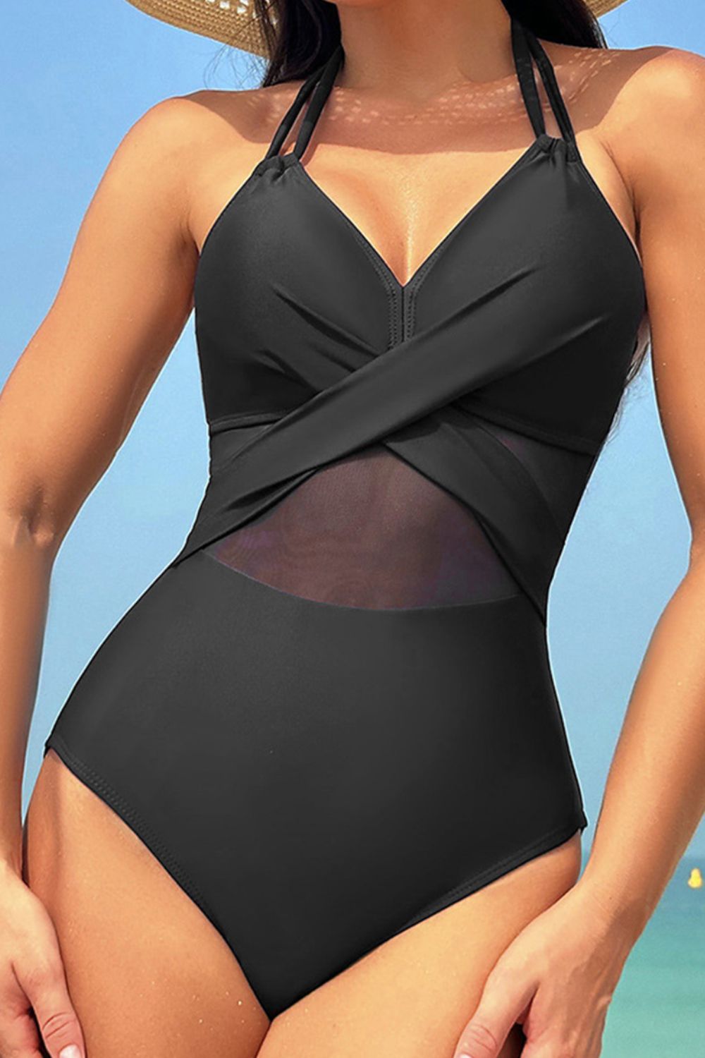 Black swimsuit worn by a person with a clear blue sky background