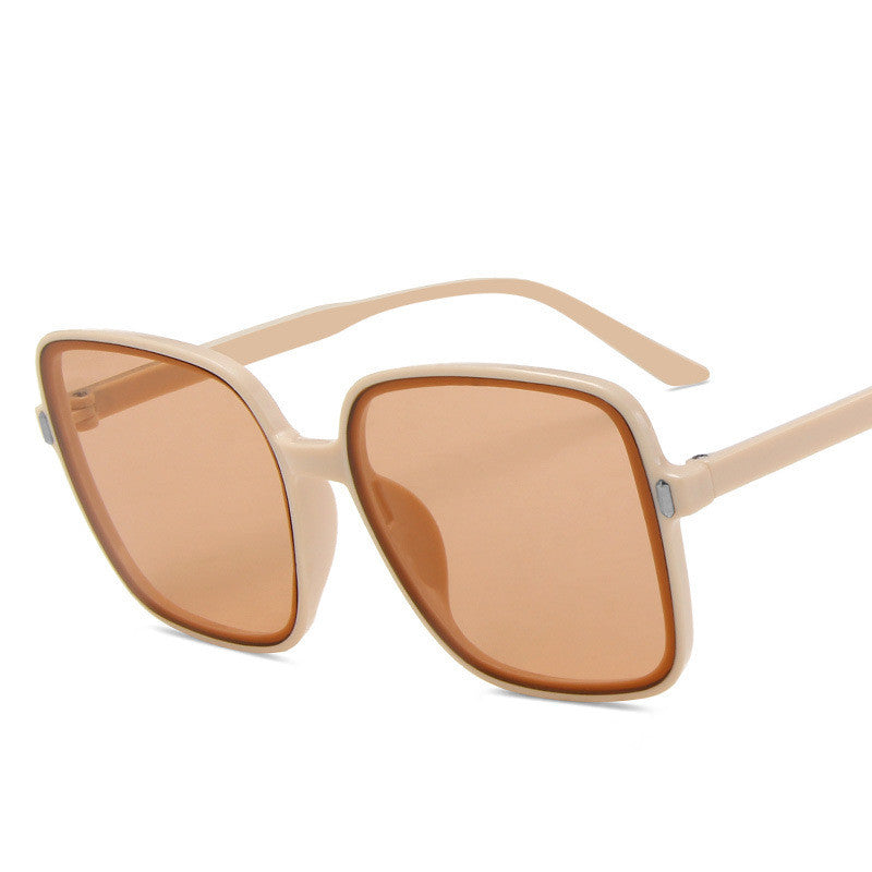 Beige sunglasses with brown lenses on a white background