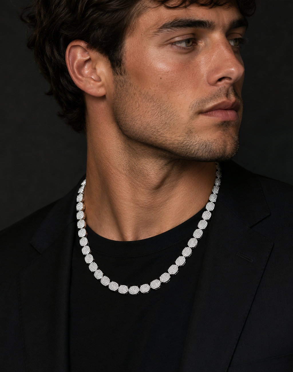 Man wearing a diamond necklace against a black background