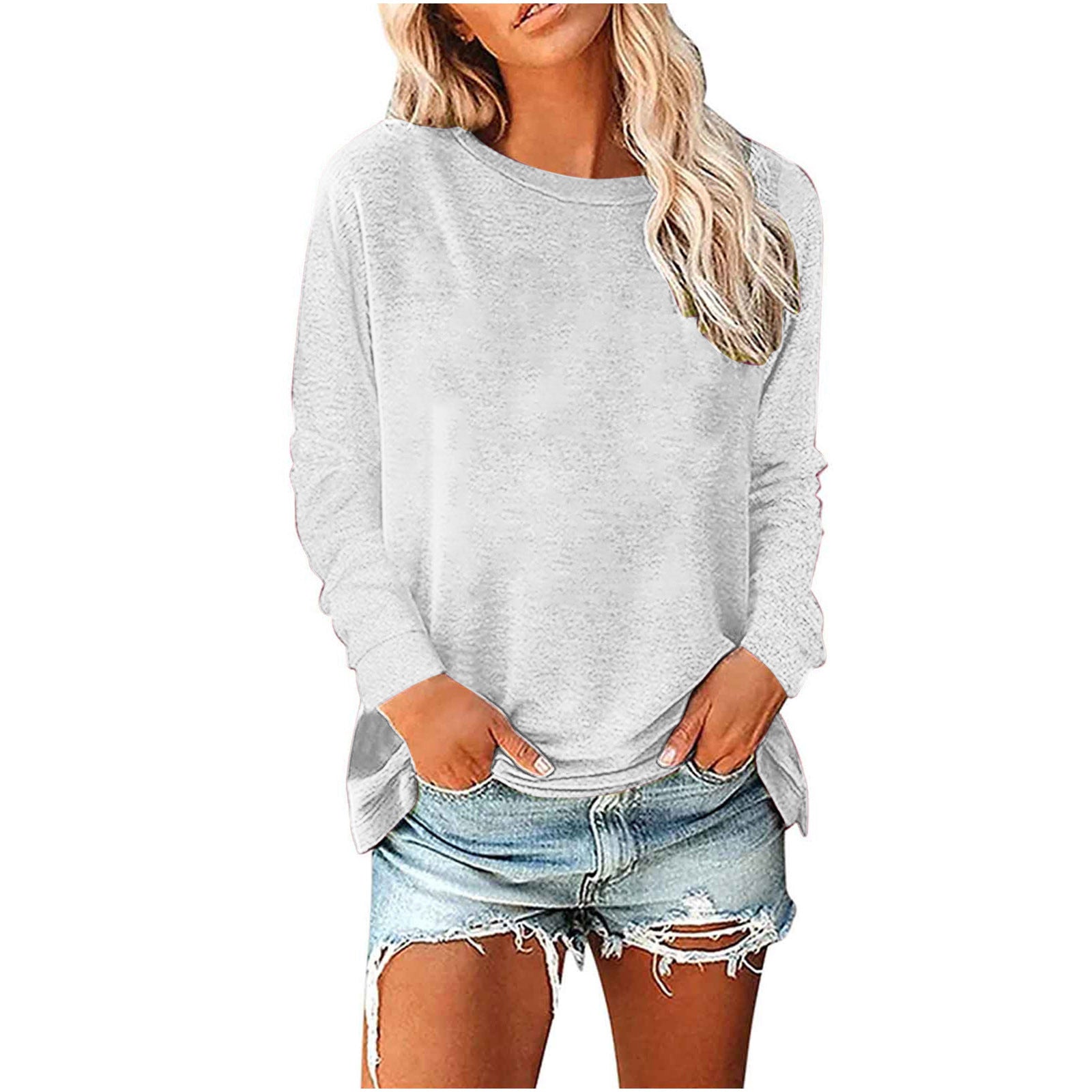 Woman wearing a gray long-sleeve top and denim shorts on a white background