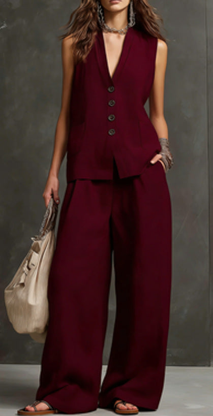 Person wearing a burgundy suit with wide-leg pants against a gray background