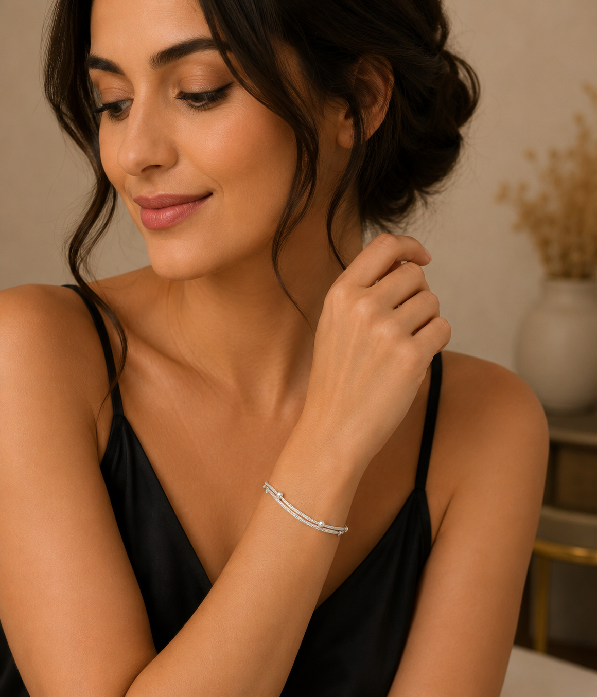 Woman wearing a silver bracelet, with a neutral background
