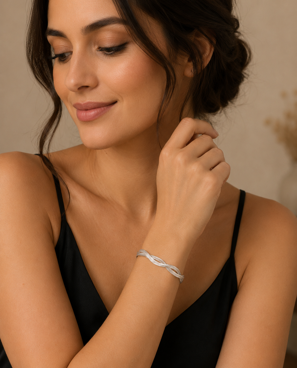 Woman wearing a silver bracelet on a neutral background