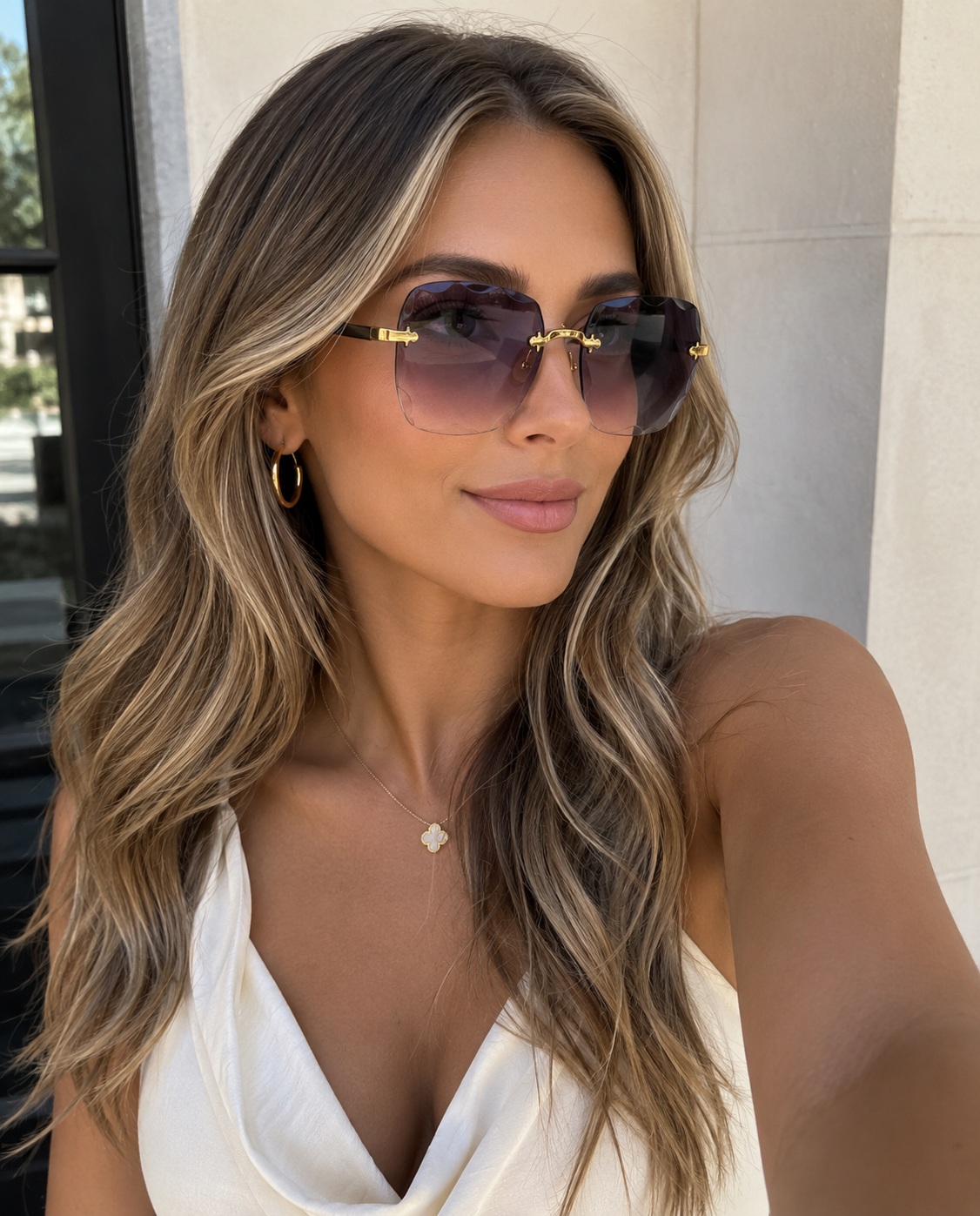 Woman wearing sunglasses and a white top outdoors