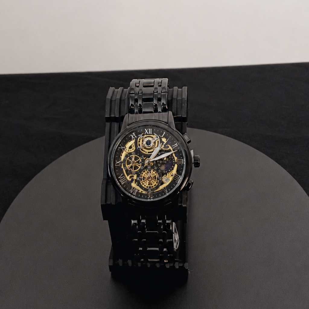 Black wristwatch with gold details on a black platform against a white background