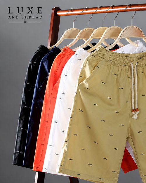 Beige shorts with a pattern on hangers against a gray background, branded 'Luxe and Thread'.