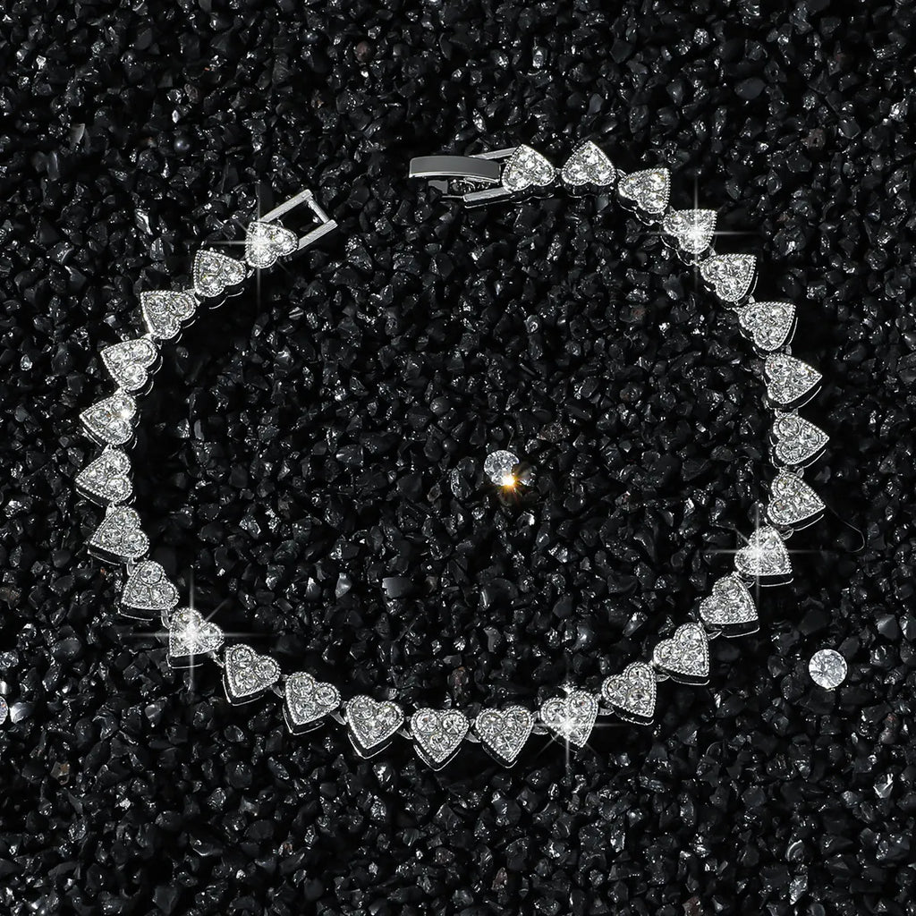 Silver bracelet with heart-shaped diamonds on a black textured background