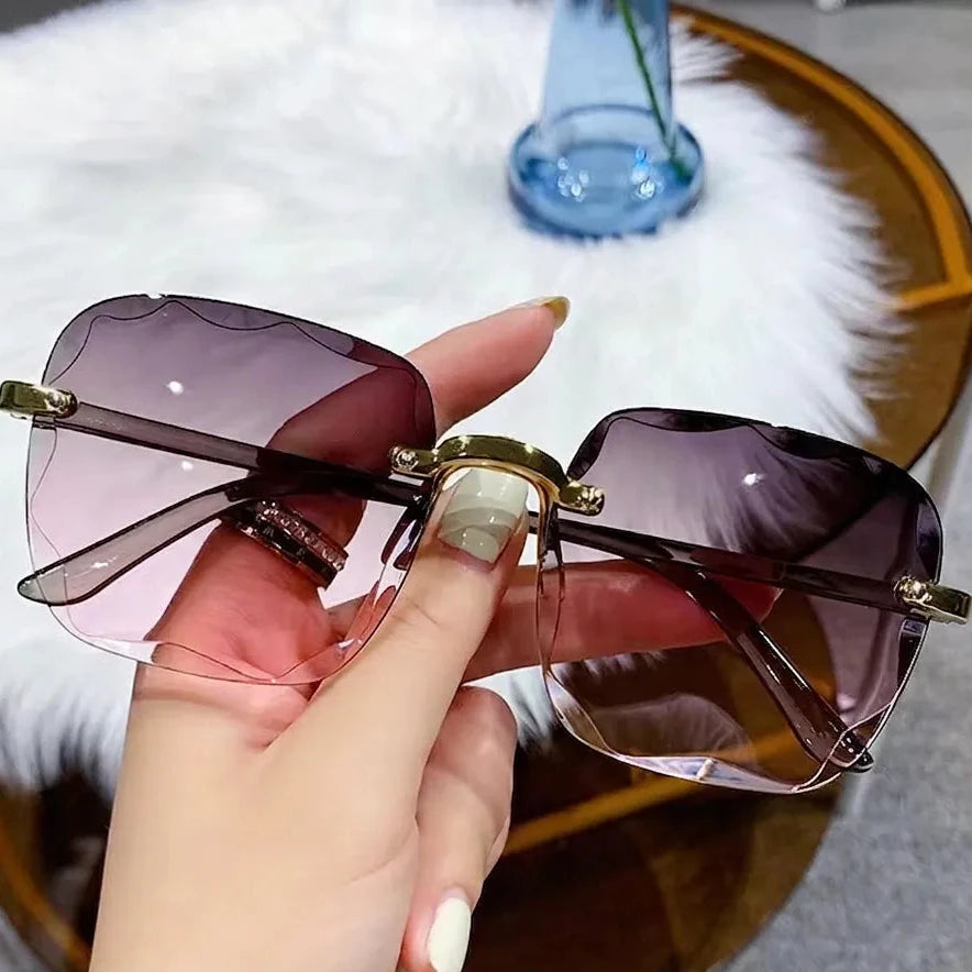 Sunglasses with gradient lenses held by a hand, with text indicating color gradient.