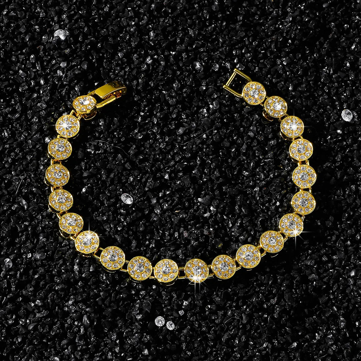 Gold bracelet with clear stones on a black textured background