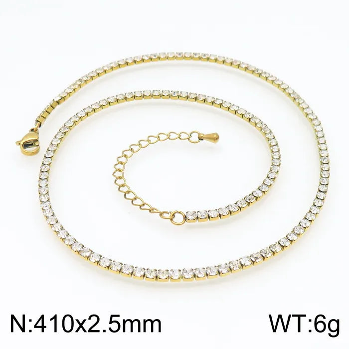 Gold necklace with clear stones on a white background