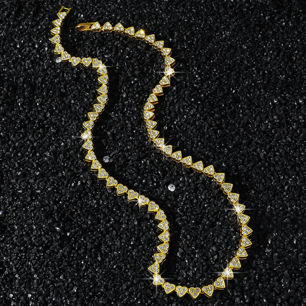 Gold necklace with diamond accents on a black textured background