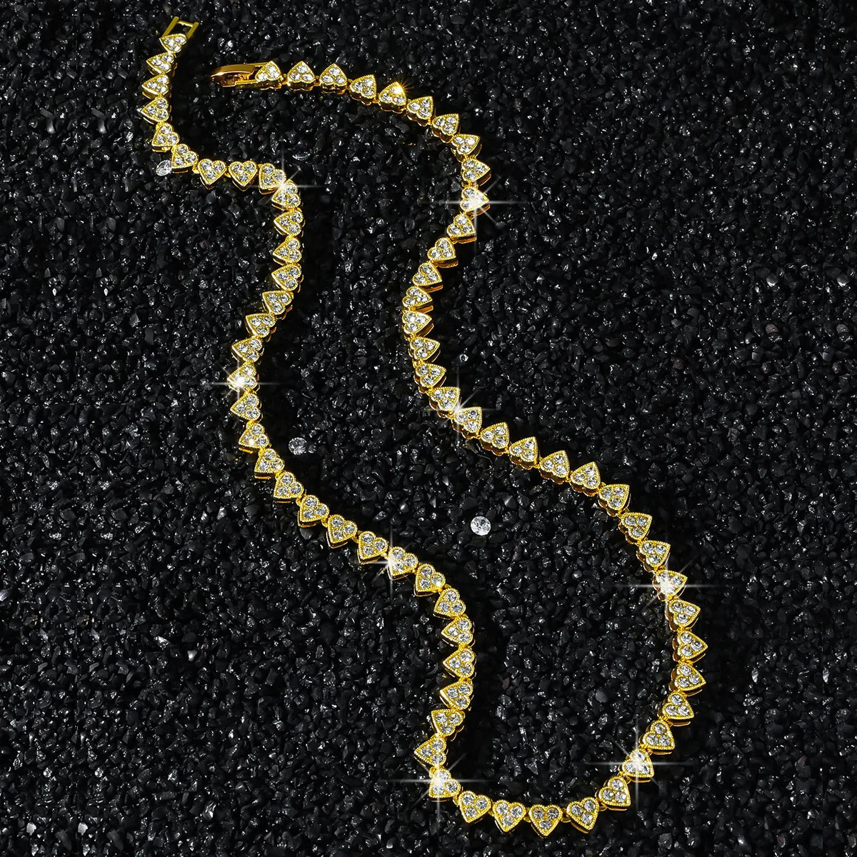 Gold necklace with diamond accents on a black textured background