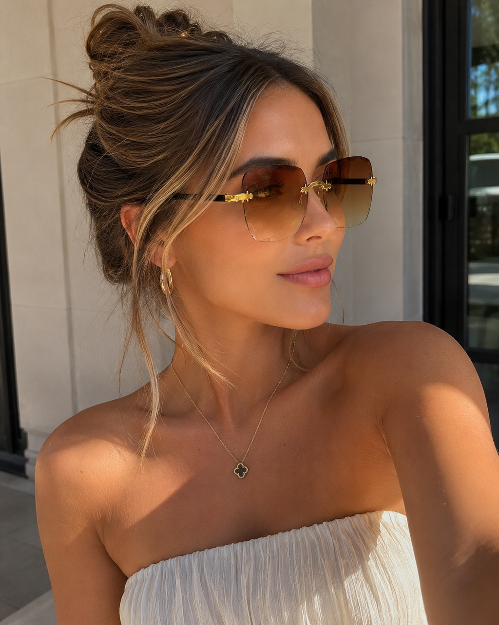 Woman wearing sunglasses and a strapless white top outdoors