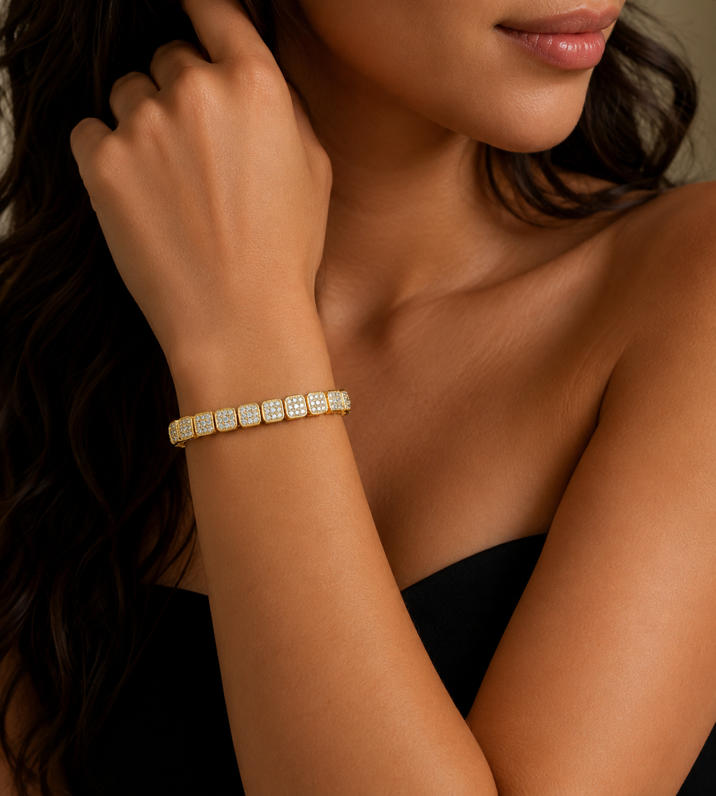Close-up of a woman's arm wearing a gold bracelet with a blurred background