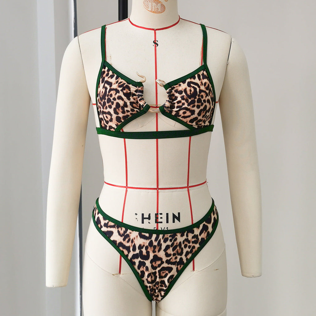Leopard print swimsuit with green trim on a mannequin against a plain background