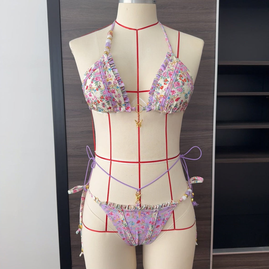 Floral bikini set on a mannequin with a grid for measurement against a neutral background
