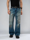Person wearing distressed blue jeans on a plain background