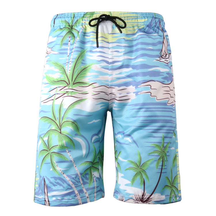 Beach shorts with tropical design featuring palm trees and a sailboat on a blue background.