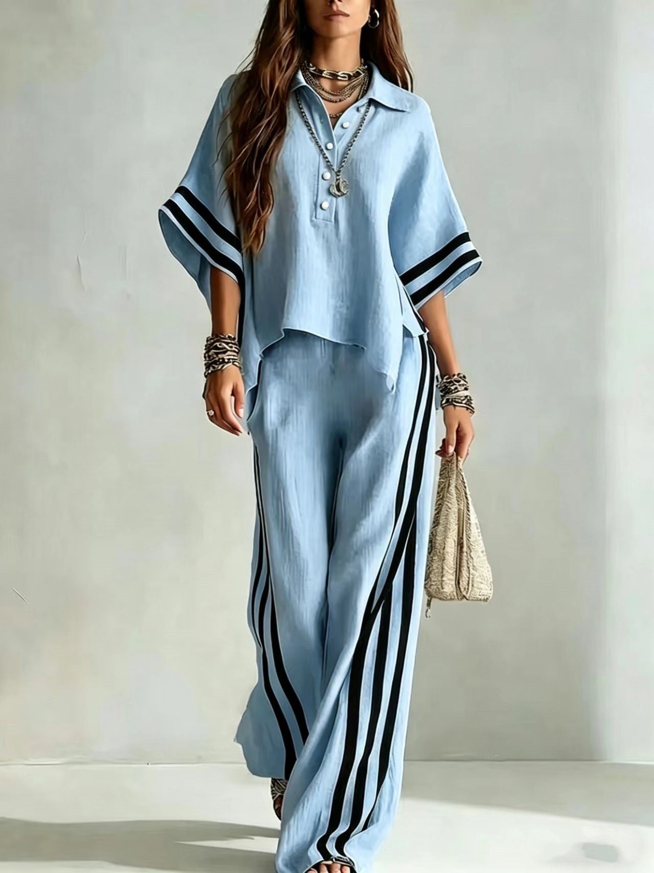 Woman wearing a light blue outfit with black stripes against a plain background