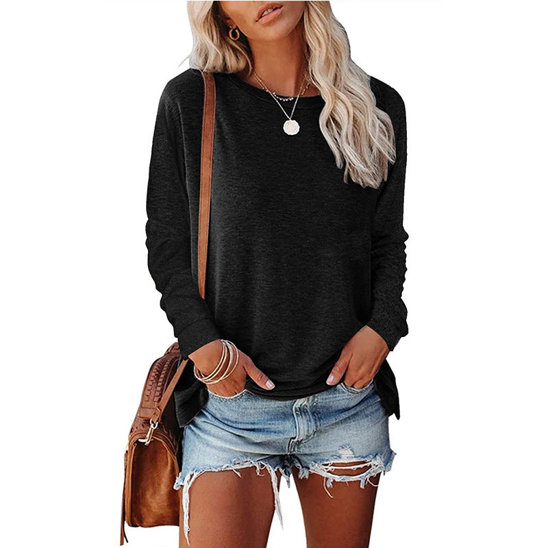 Woman wearing a black long-sleeve top and denim shorts, holding a brown bag on a white background.
