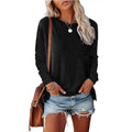 Woman wearing a black long-sleeve top and denim shorts, holding a brown bag on a white background.