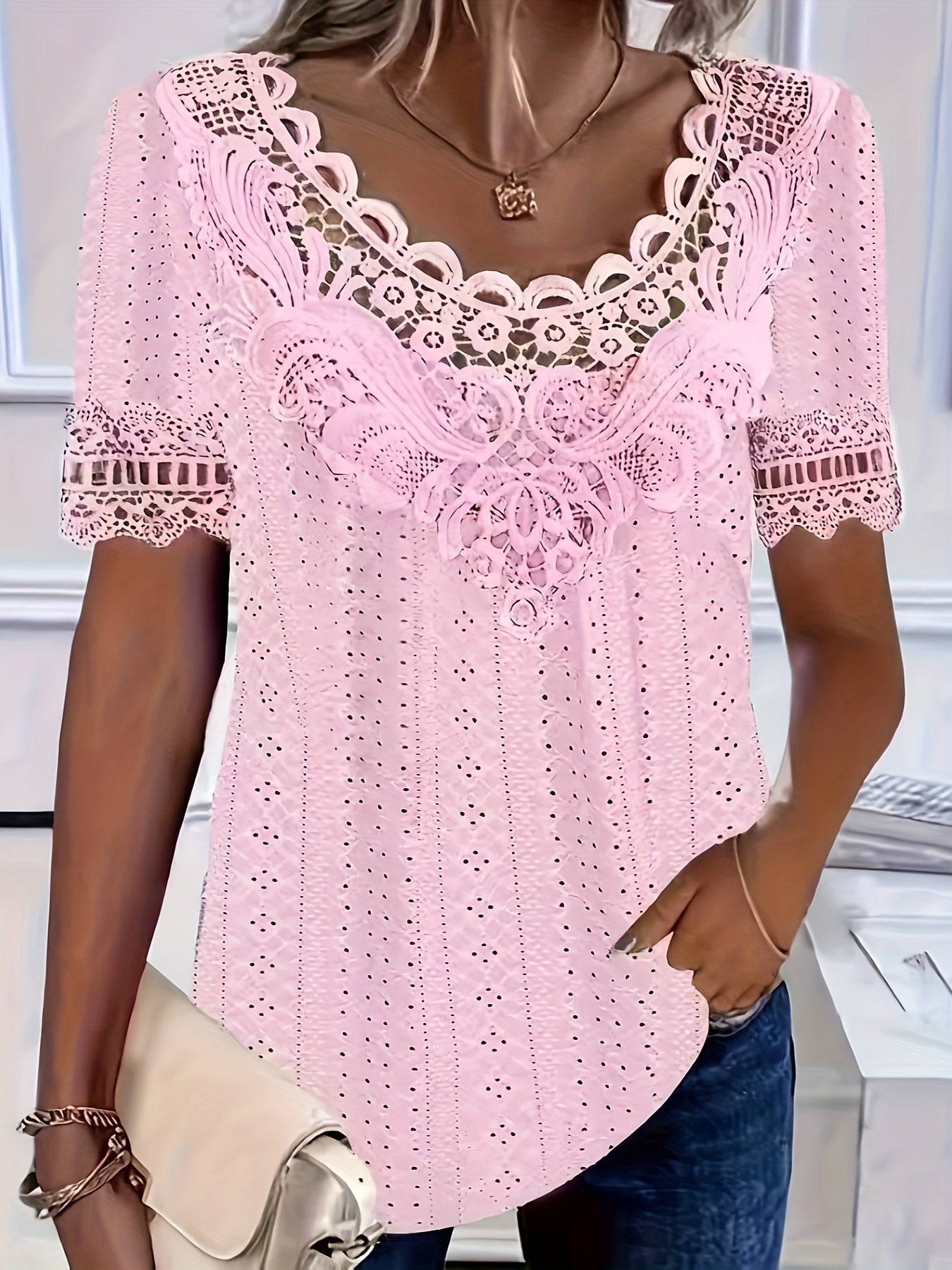 Pink lace top worn by a person, with a blurred indoor background