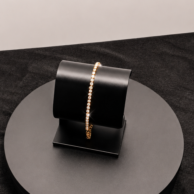 Black jewelry stand with a gold bracelet on a black surface
