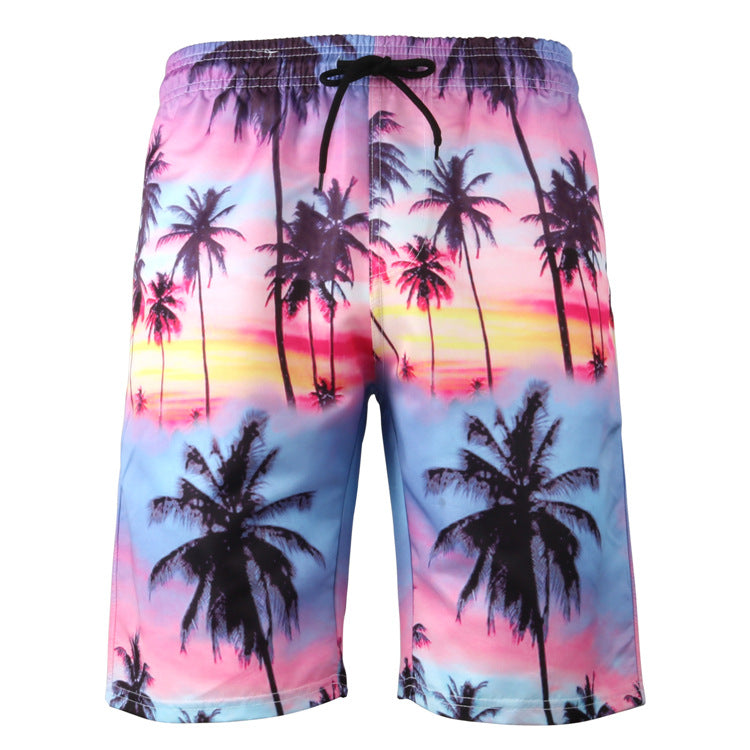 Beach shorts with palm tree and sunset design on a white background
