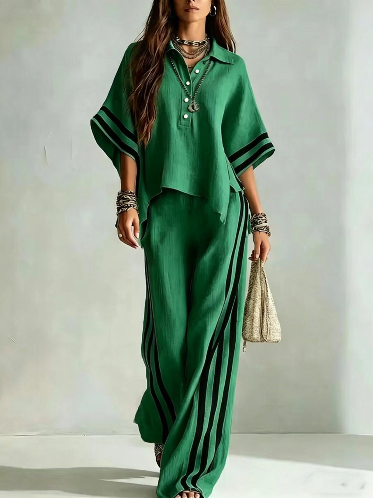 Woman wearing a green outfit with black stripes against a plain background