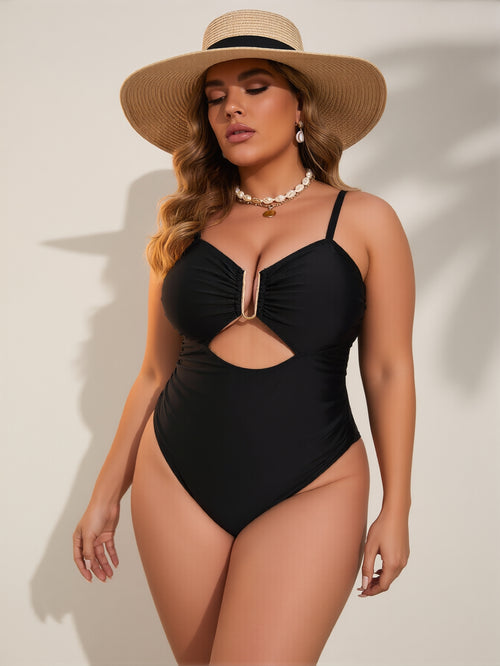 Woman wearing a black swimsuit and straw hat on a beige background