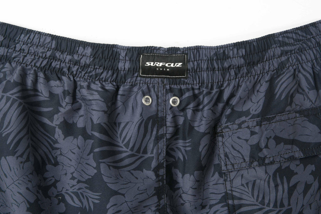Navy blue swim shorts with leaf pattern and Surf Club label on a white background